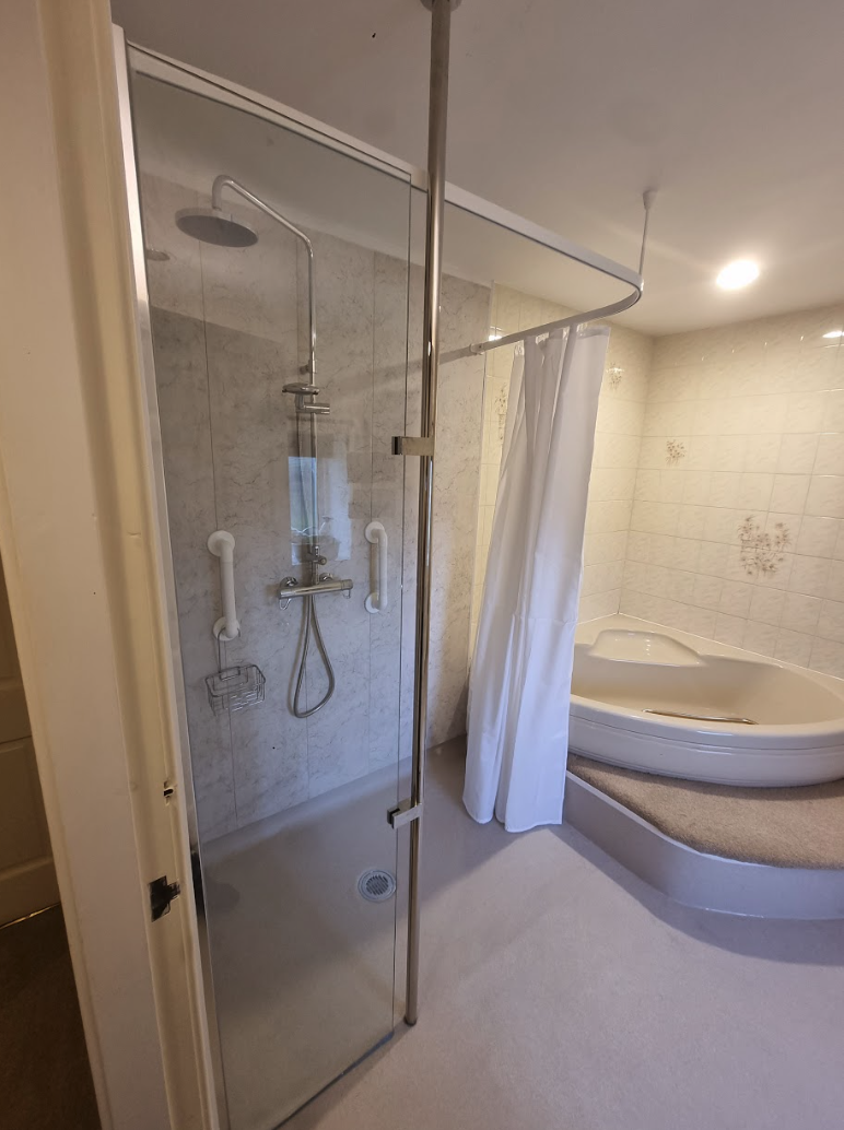 Completed Bakewell wet room with retained bath and support pole